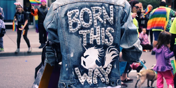 Eine Person in einer Lederjacke die eine Aufschrift trägt: Born this way.