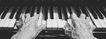 Zwei Hände die auf einem Klavier spielen.